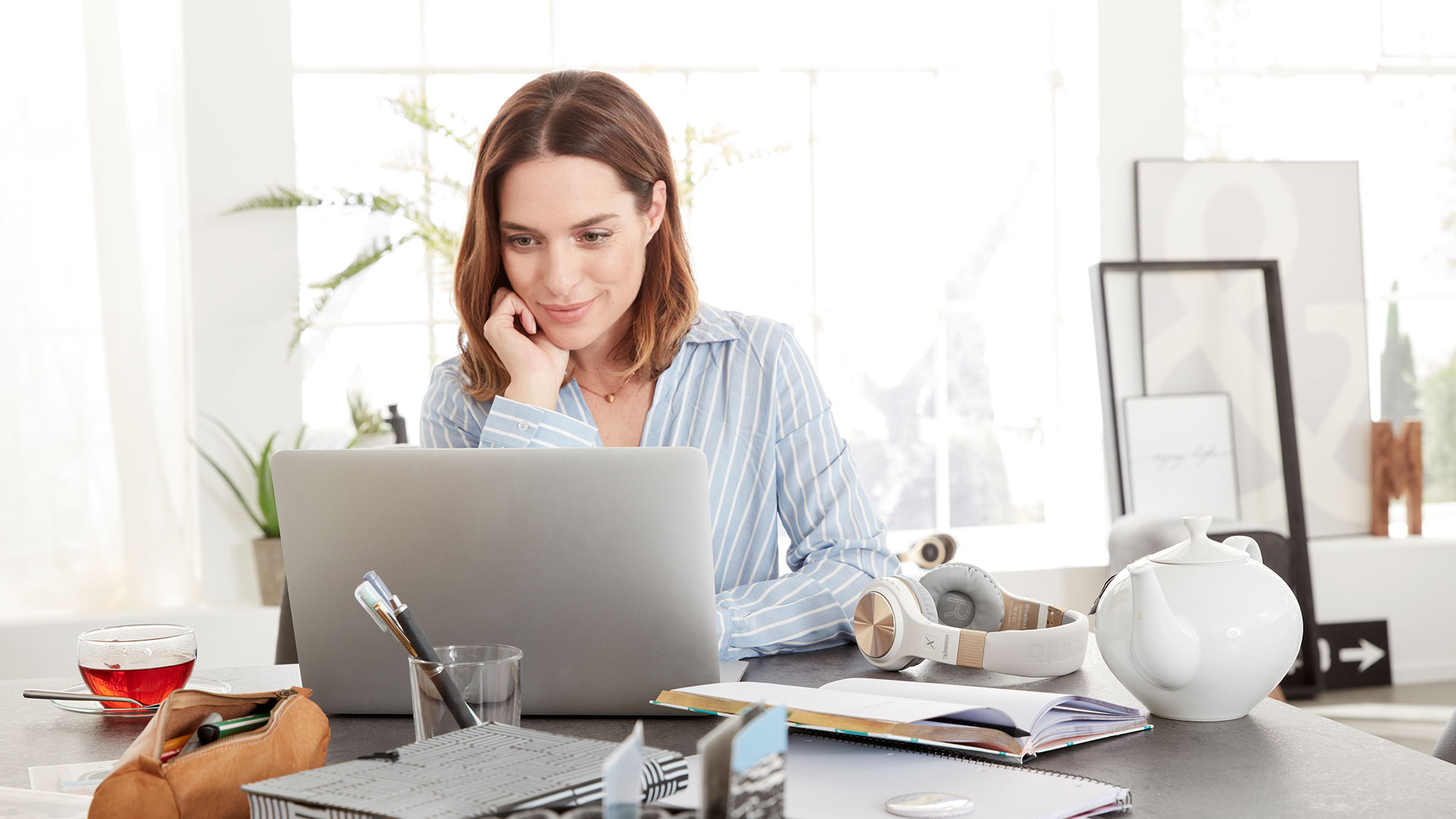Frau schaut sich an ihrem Laptop den virtuellen Rundgang an.